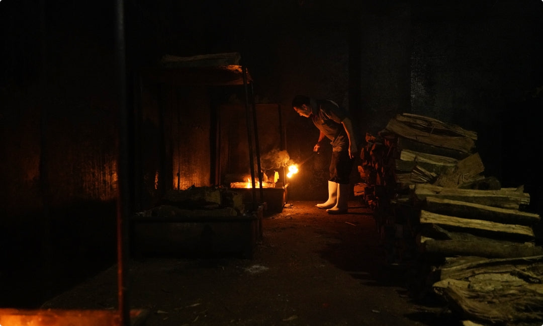 焙乾方式の薪に火をつけている様子。